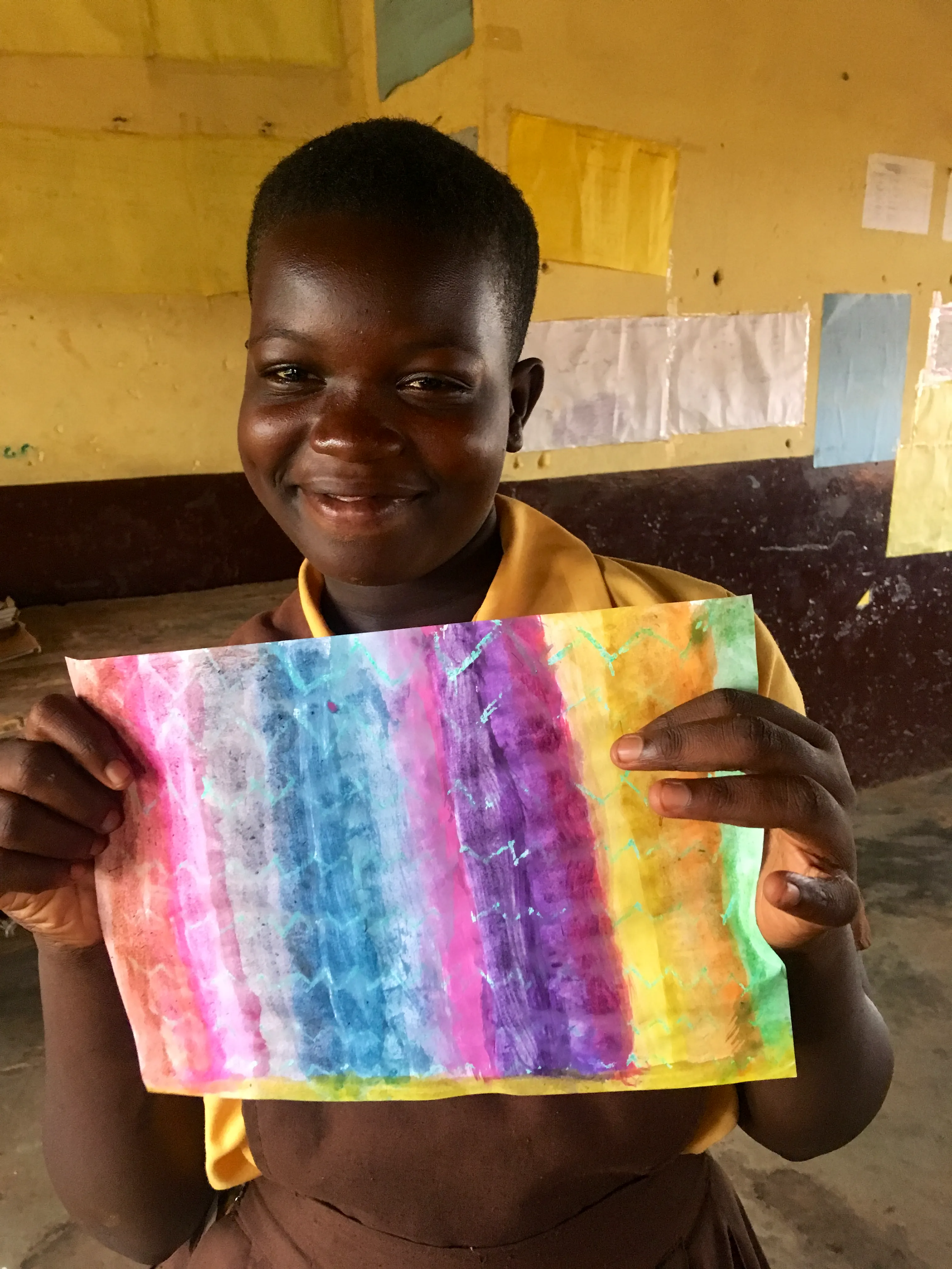 Un niño muestra orgulloso la pintura que hizo